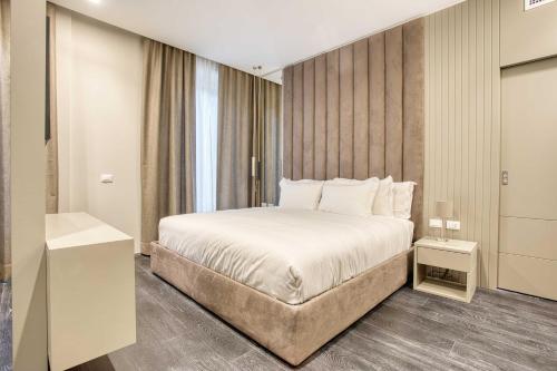 sypialnia z dużym łóżkiem i oknem w obiekcie Le Suite del Corso ALTIDO The Smart Boutique Aparthotel By OSPITAMI w Mediolanie