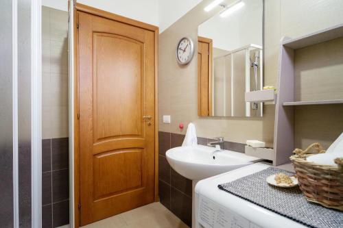 bagno con lavandino e porta in legno di Porto Frailis 2 a Tortolì