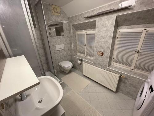 Haus Kampl - Appartement Grundlsee في باد ميترندورف: حمام مع حوض أبيض ومرحاض