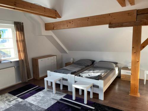 um quarto com uma cama e algumas vigas de madeira em Haus Kampl - Appartement Grundlsee em Bad Mitterndorf
