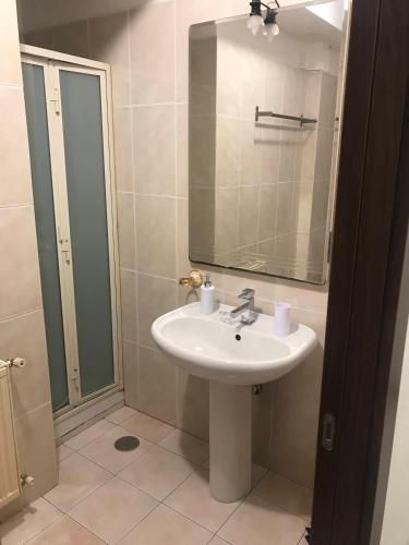 a bathroom with a sink and a mirror and a shower at Calipso Bed&Breakfast in Catania