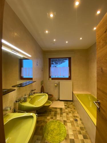 Chalet Tauernbär في غروسكرتشاين: حمام فيه مغسلتين وحوض استحمام ودوبي