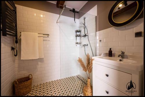 a white bathroom with a sink and a shower at Hankówka Mazury in Jerutki