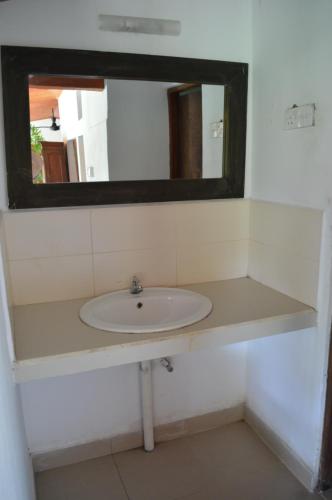 ein Bad mit einem Waschbecken und einem Spiegel in der Unterkunft The Lodge at Galapitiyaya Estate in Haputale