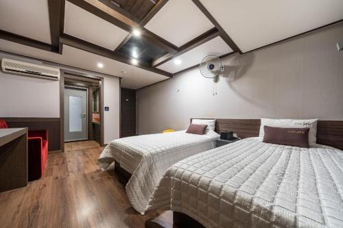 a bedroom with two beds and a ceiling at MU Hotel Sasang in Busan