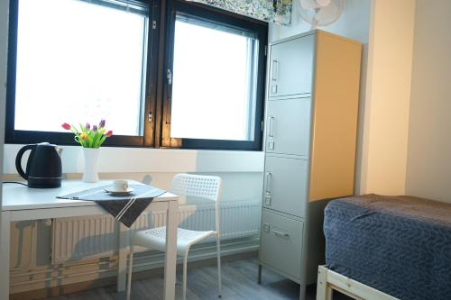 a bedroom with a desk and a bed and a table and chair at Inn Tourist Hostel in Helsinki