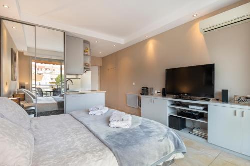 une chambre avec un grand lit et une télévision dans l'établissement Palais Rouaze Cannes, à Cannes
