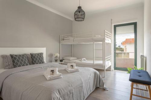 a white bedroom with a bed with two towels on it at Casa da Légua in Moledo