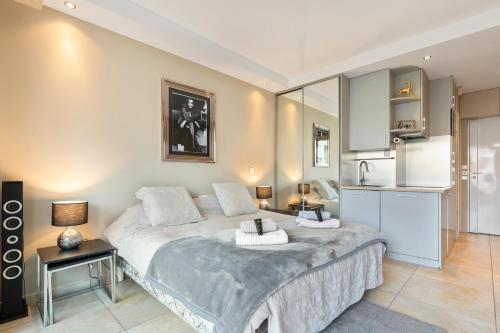 une chambre avec un grand lit et une cuisine dans l'établissement Palais Rouaze Cannes, à Cannes
