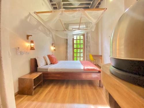 sypialnia z łóżkiem i oknem w obiekcie Cafe Central w mieście Mozambik