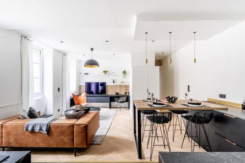 une cuisine et un salon avec un canapé et une table dans l'établissement Le Passage Royal - Les Maisons de Madeleine, à Nantes