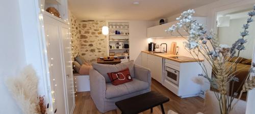 un salon avec une chaise et une cuisine dans l'établissement Bienvenue au Cocon Chaumois - Les Sables d'Olonne - La Clé Chaumoise, à La Chaume