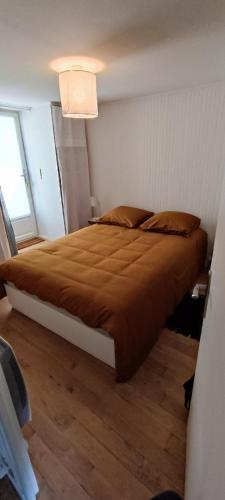 une chambre avec un grand lit avec une couverture marron dans l'établissement Bienvenue au Cocon Chaumois - Les Sables d'Olonne - La Clé Chaumoise, à La Chaume