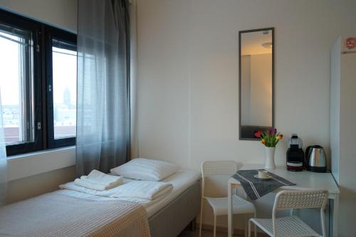 a bedroom with a bed and a table and a window at Inn Tourist Hostel in Helsinki