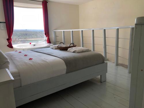 a bedroom with a bed with a window and a tub at אלרון - אירוח בגולן in Ani'am