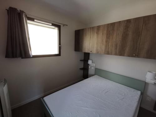 a small bedroom with a bed and a window at Ô Doubs Chalets in Mouthe