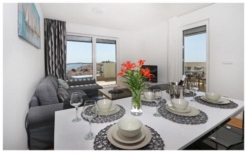 a living room with a table with plates and glasses at Royal Primošten in Primošten