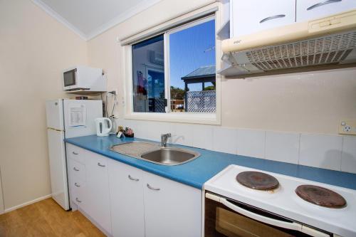 a small kitchen with a sink and a window at Reflections Evans Head - Holiday Park in Evans Head