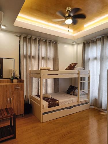 a bedroom with two bunk beds and a ceiling fan at Andrew n Sophia's Guest House in Puerto Princesa City