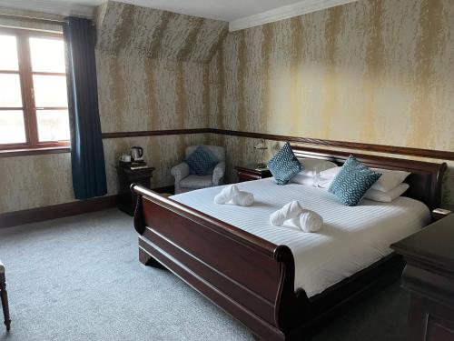 a bedroom with a large bed with blue pillows at Craigdarroch Hotel in Foyers