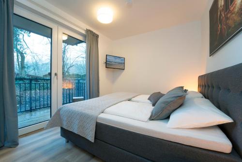 - une chambre avec un lit et une grande fenêtre dans l'établissement Am Yachthafen, à Neustadt in Holstein