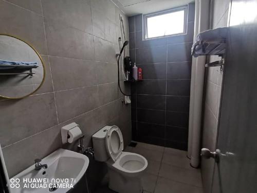 a bathroom with a toilet and a sink and a mirror at HK Homestay in Ipoh
