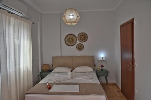 Lagouvardos Apartments في ماراثوبوليس: غرفة نوم بها سرير و قلادة خفيفة