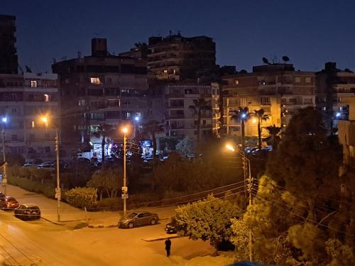 eine Stadt in der Nacht mit Autos auf einer Straße in der Unterkunft Hijaz Street Hotel in Kairo