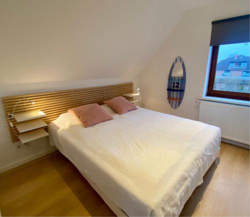 a bedroom with a large white bed with a window at Deichtraum - 1020 in Dahme
