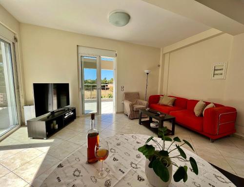 a living room with a red couch and a tv at Dionysis Villas in Skala