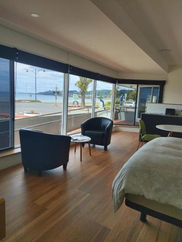 Un dormitorio con una cama y sillas y una gran ventana. en Empty Nest, en Penguin