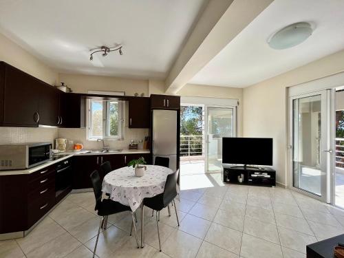 a kitchen with a table with chairs and a television at Dionysis Villas in Skala