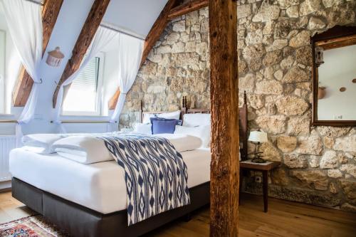 a bedroom with a large bed in a stone wall at Gasthof Lend-Platzl in Graz