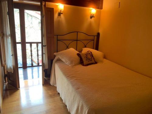 a bedroom with a bed with two pillows on it at El Corral de Baxo in Felechosa
