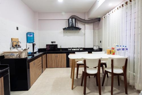 a kitchen with a white table and white chairs at Satsang Homestay in Kathmandu