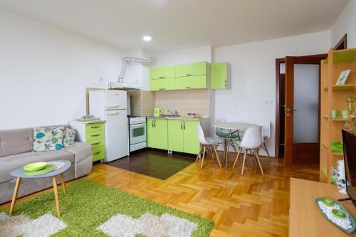een keuken en een woonkamer met een bank en een tafel bij Apartman Green in Lukavica