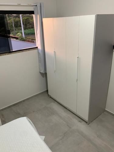 a room with white cabinets and a window at Trindade Beach House in Paraty