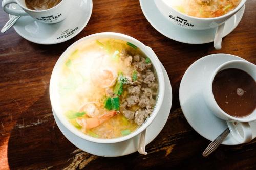 a bowl of soup on a table with a cup of coffee at Baan Tah On The Sea in Bang Sare