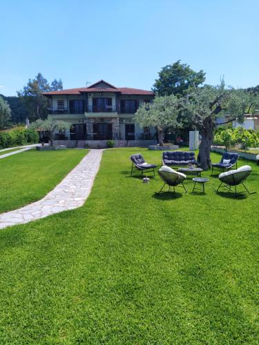 a group of chairs and tables on a lawn at GORGONA VILLAS in Vourvourou