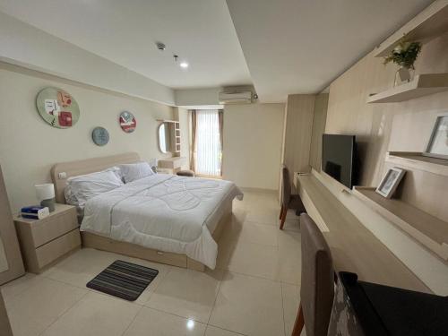 a bedroom with a bed and a flat screen tv at Louis Kienne Simpang Lima in Semarang
