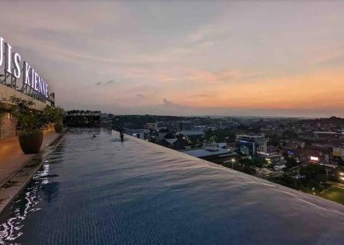 a swimming pool on the roof of a building with a city at Louis Kienne Simpang Lima in Semarang