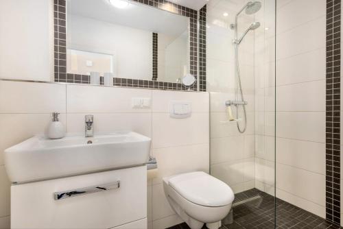 a bathroom with a sink and a toilet and a shower at Ferienwohnung Boddenblick in Puddemin