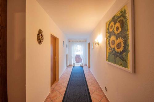 a hallway with a painting of flowers on the wall at Haus Hubertus in Mieders
