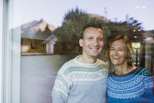 a man and a woman standing in front of a window at Lofoten Planet BaseCamp in Sørvågen