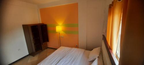a bedroom with a bed and a lamp in it at ABT Apartments Bonapriso-7Mins From Airport in Douala