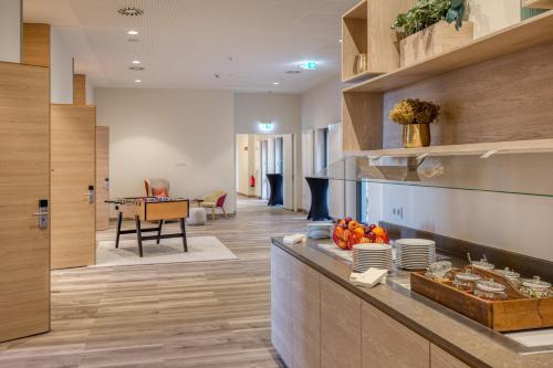 a kitchen with a counter and a dining room at IntercityHotel Berlin Airport BER Terminal 1 & 2 in Schönefeld