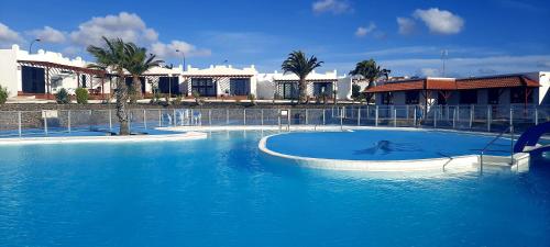 una gran piscina de agua azul frente a un edificio en Sun beach Caleta 24, en Caleta de Fuste