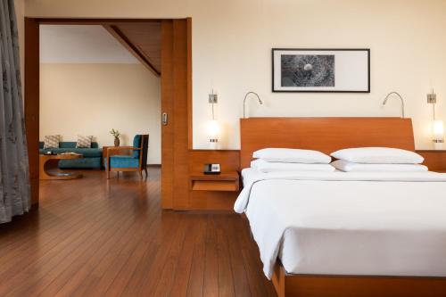 a hotel room with a bed and a living room at Hyatt Pune in Pune