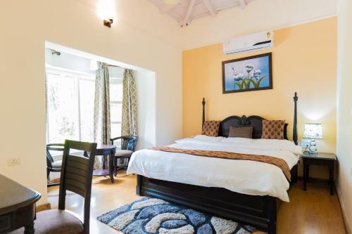 a bedroom with a large bed and a table at Neelesh Inn- A Luxury Lake View Hotel- 20 kms from Nainital in Bhīm Tāl