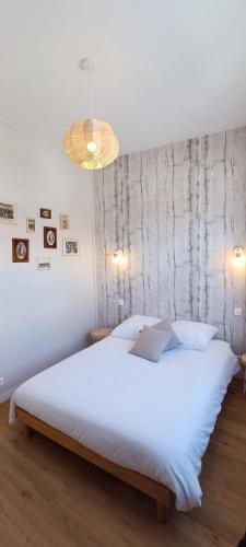 - une chambre avec un grand lit blanc et un lustre dans l'établissement Maison de pêcheur agréable & chaleureuse-La Chaume - La Clé Chaumoise, à La Chaume